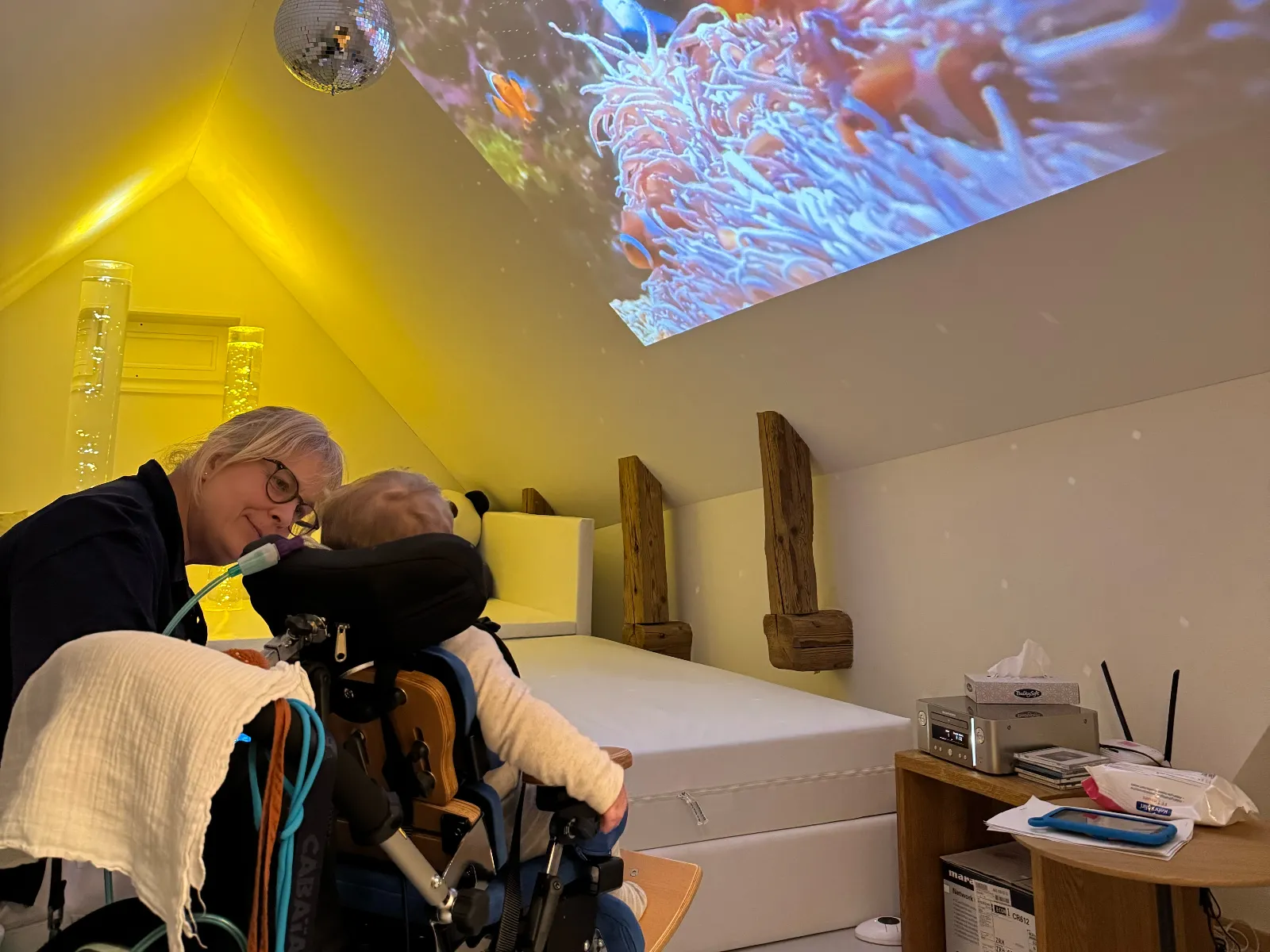 Pflegeperson betreut ein Kind im Snoezelenraum