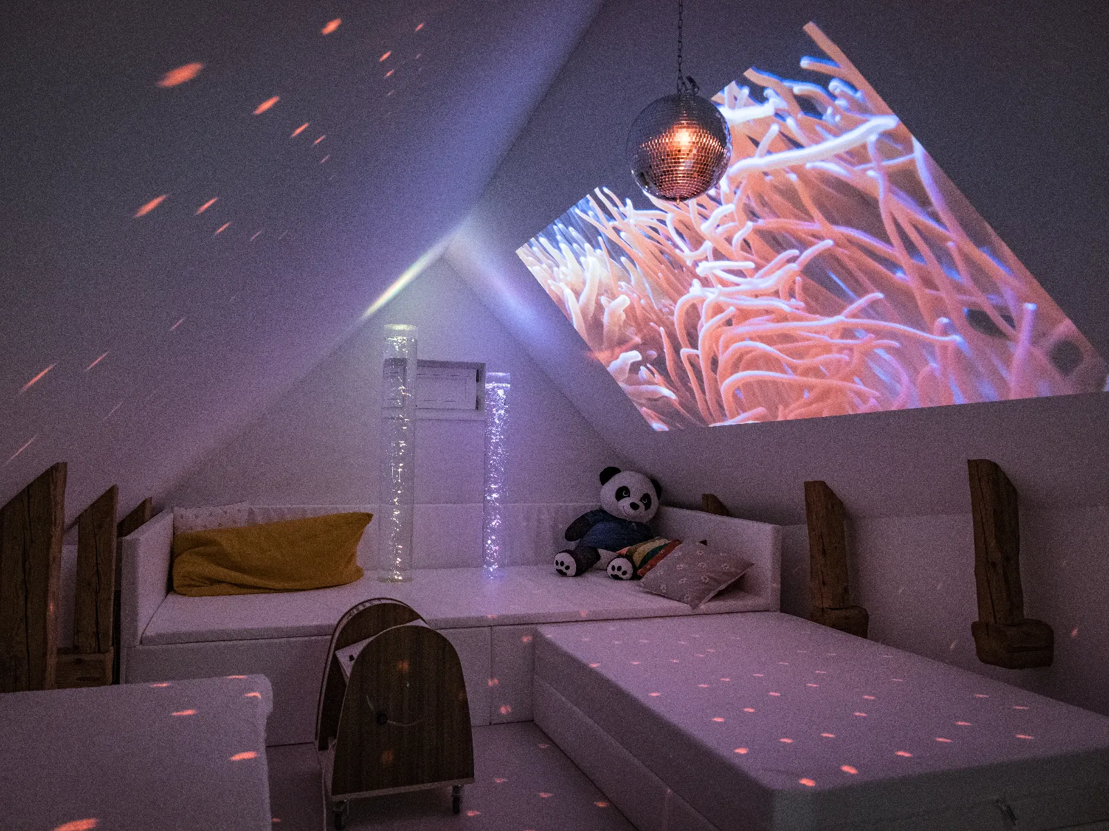 Snoezelenraum mit farbiger Beleuchtung und Unterwasserwelt an der Wand