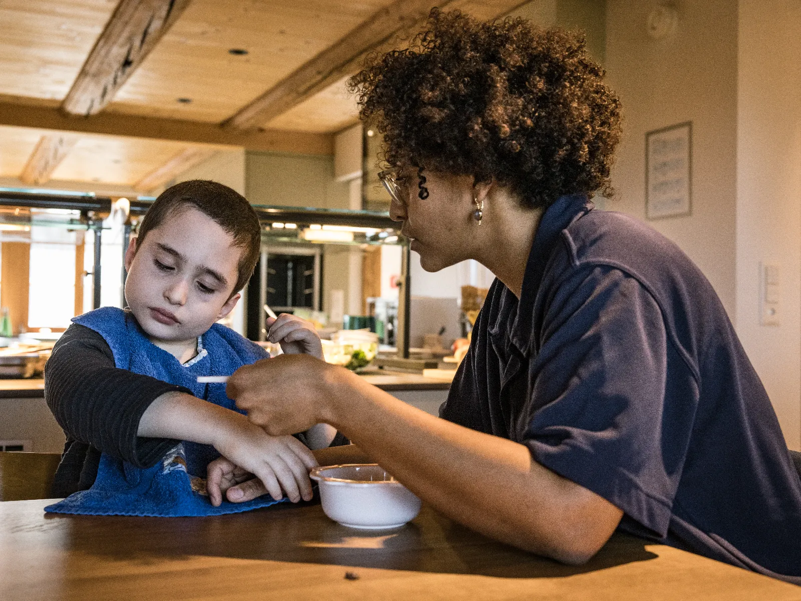 Pflegeperson füttert ein Kind