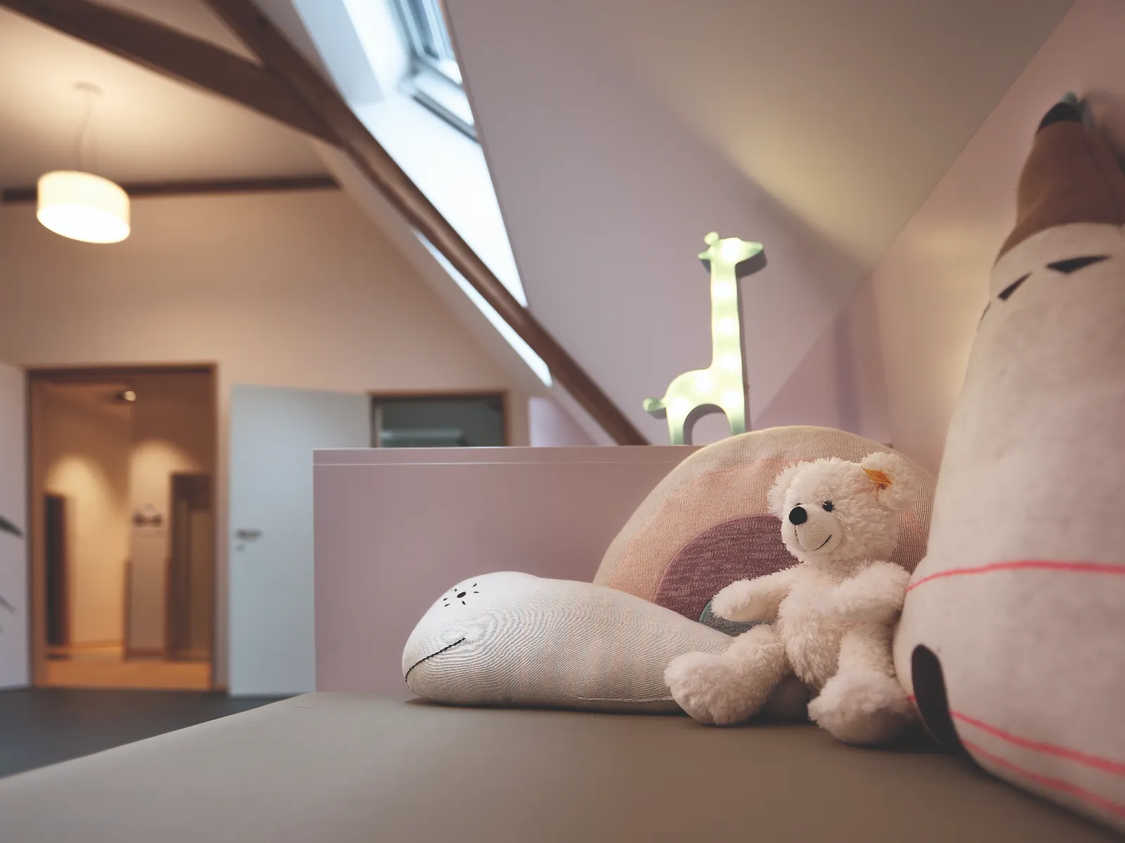 Teddybär und Kuschelkissen auf einer Sitzbank