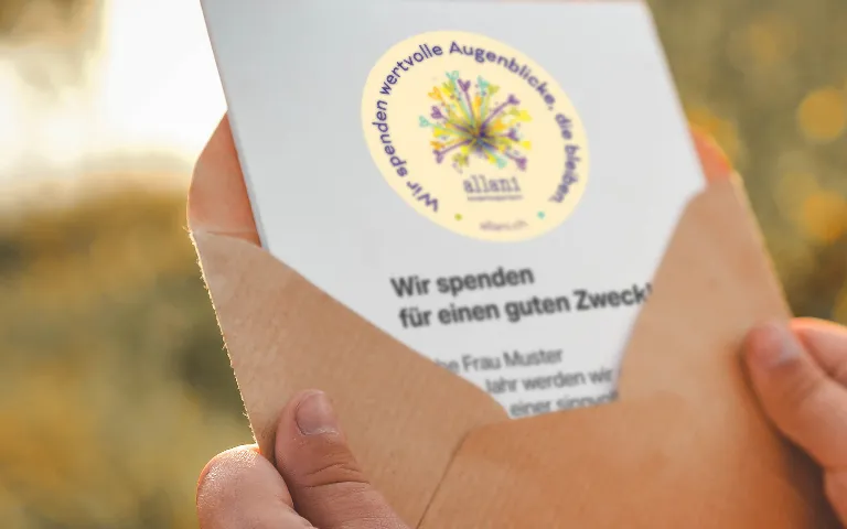 Geöffnetes Kuvert mit Brief, versehen mit dem allani Spendenstempel