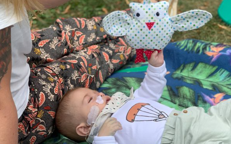 Kind spielt mit genähter Eule