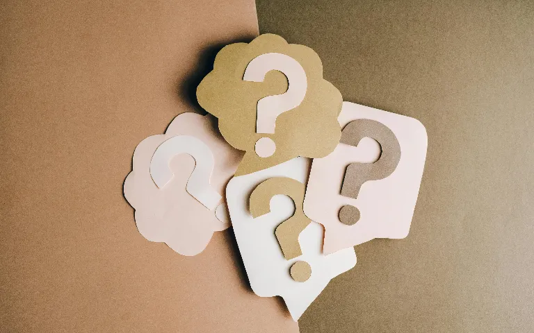 Symbolbild mit vier Fragezeichen für häufige Fragen (FAQs)